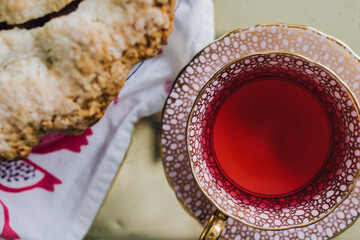 top down, directly above shot of pink hibiscus tea in teacup next to homemade pie