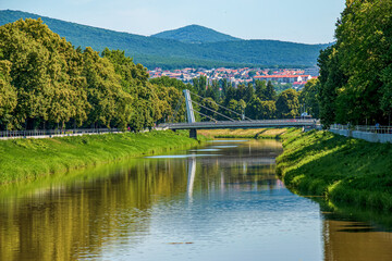 Fototapeta na wymiar View of the Slovak city of Nitra. View of the Nitra River, a modern bridge and characteristic red European