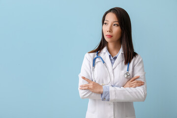 Female Asian doctor on blue background