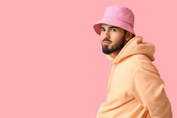 Fashionable bearded man in stylish clothes on pink background