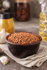 Bowl with buckwheat grains and napkin on table