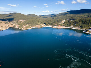 Fototapeta premium Aerial winter view of Dospat Reservoir covered with ice, Bulgaria