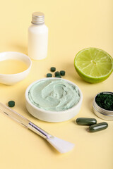 Composition with jar of spirulina facial mask and ingredients on color background