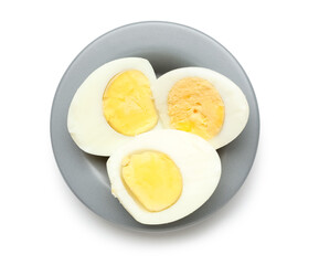 Plate with cut boiled eggs on white background