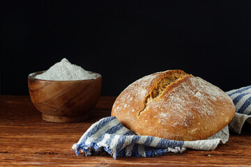 Homemade wheat-rye bread on a linen towel on a wooden table