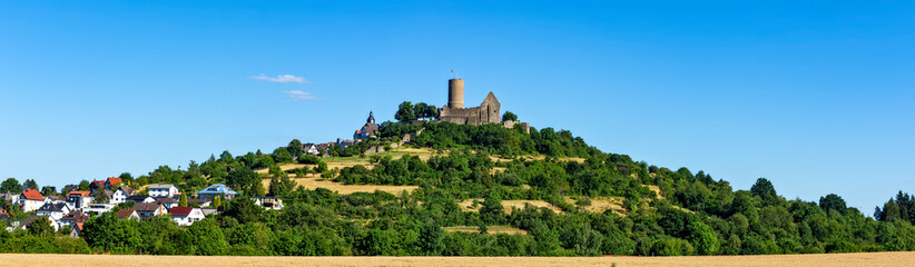 Fototapeta na wymiar Die auf dem Gipfel eines Vulkanbergs liegende mittelalterliche Ruine der Burg Gleiberg bei sonnigen Wetter und wolkenlosem Himmel, Hessen, Deutschland