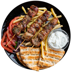 Traditional Albanian grilled meat shish kebab garnished with flatbread, french fries, fresh...