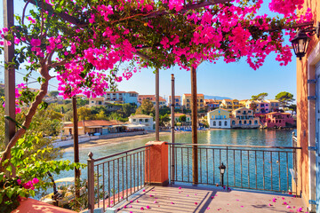 Fototapeta na wymiar Colorful houses view from balcony with bougainvillea flowers in Assos village on Kefalonia Island, Greece