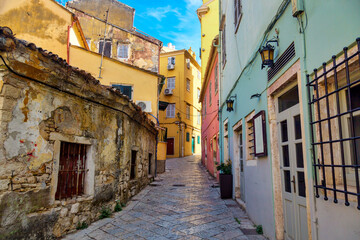 Kerkyra city narrow street view with colorful houses during sunny day. Corfu Island, Ionian Sea, Greece.