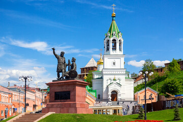 Naklejka premium Monument to Minin and Pozharsky with Orthodox church in Nizhny Novgorod, Russia. Summer sunny day