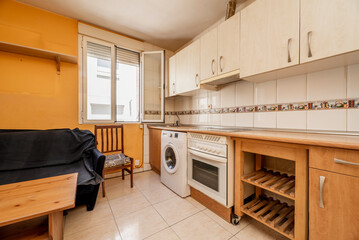 Kitchen front with cherry wood furniture in the lower part and light furniture in the upper part with integrated white appliances