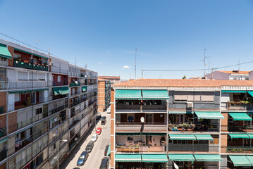 Facades of urban residential buildings with clay roofs and television antennas on a sunny day