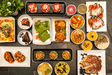 Set of varied healthy food dishes with vegetables, berries, vegan chocolate tarts and roasted aubergines