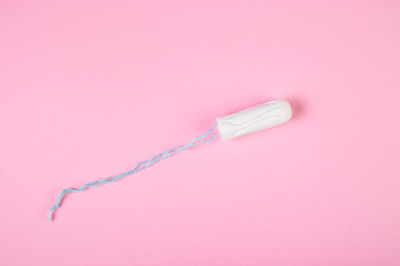Hygienic cotton tampon on pink background. Feminine menstrual hygiene product.