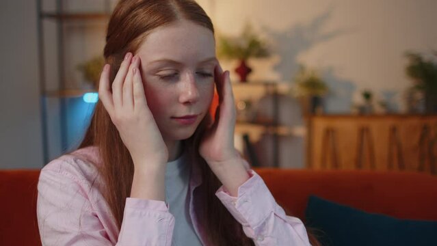 Close-up portrait of tired child kid freelancer student suffering from tension, migaine headache after e-learning, remote working job study with pupils sitting at home office. Adult girl businesswoman