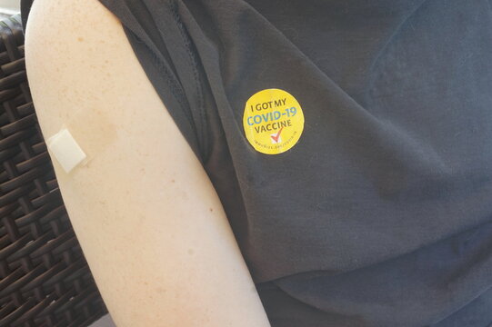 Right Arm With Bandage And Sticker On Black T Shirt Saying I Got My Covid Vaccine