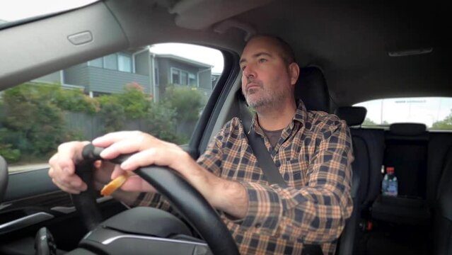 Time lapse front view of a mature man driving a car, eating toast and waking up.