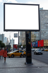 Empty billboard on paving stones against the backdrop of high-rise buildings. Mock-up.