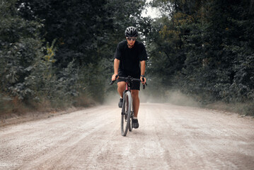 Cyclist rides gravel bike in the forest. Man cycling in the nature.
