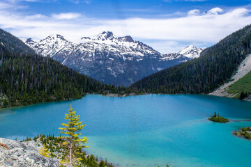 Fototapeta na wymiar Lake with blue water and snowy mountains on the background in Joffre Lakes, BC, Canada