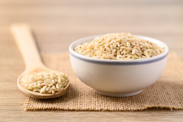 Thai brown rice seed in bowl with spoon, Organic rice grain, Food ingredients