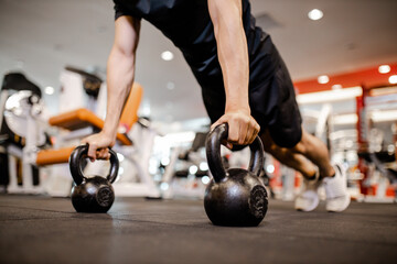 Fototapeta na wymiar Asian young man using dumbbell Pushing up exercise at gym for good healthy in fitness, Lifestyle and sport exercise concept.