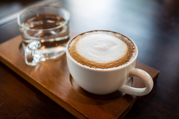 White hot latte cups and drink glasses on wooden tray