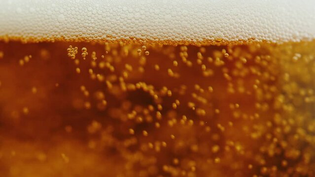 Foamy beer in glass close-up texture. Alcohol golden beer drink in mug. Fresh pale ale macro. 