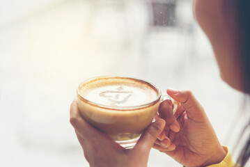 Woman holding coffee cup relaxing after work at office warm taste in cafe. Close up hands of woman...