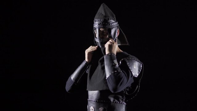 Mongolian Warrior in the Historical Period. Black background.
Warrior puts on his helmet. Historical period video.
