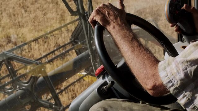 Male Hands Farmer Driver On Steering Wheel Combine Harvest On Agricultural Field. View From Inside Tractor Driver Turns Steering Wheel Agricultural Machine. Prores, Slow Motion, 4k