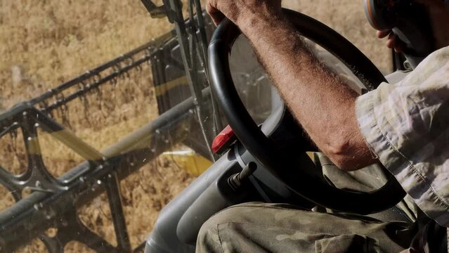 Male Hands Farmer Driver On Steering Wheel Combine Harvest On Agricultural Field. View From Inside Tractor Driver Turns Steering Wheel Agricultural Machine. Prores, Slow Motion, 4k