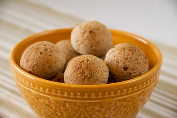 yellow bowl full of brazilian cheese bread - pao de queijo integral - Brazilian Food