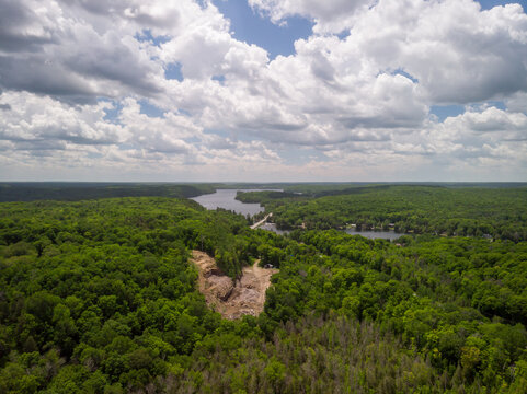 A small open-pit rock quarry has been carved out of a forested hillside.