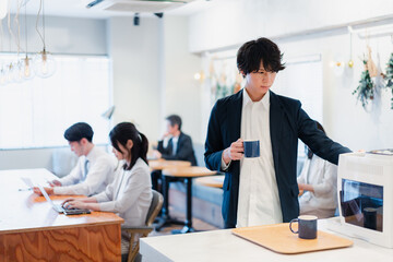 シェアオフィスでコーヒーを飲むビジネスマン