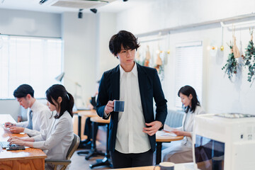 Fototapeta premium シェアオフィスでコーヒーを飲むビジネスマン