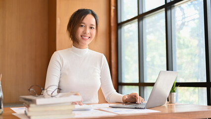 Asian businesswoman or female financial analysts working at her office desk.