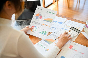 Businesswoman or financial worker reading a financial data chart and graph on the report