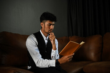 Thoughtful asian businessman or male boss focused reading book