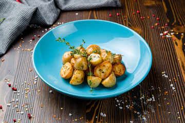 baked mini potatoes on blue plate on wooden table