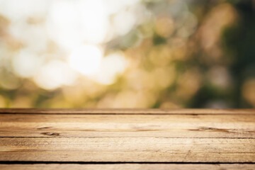 Empty blank wooden plank, deck or table with defocused green trees background