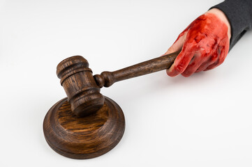 Female judge with bloody hands beats the gavel on a white background.