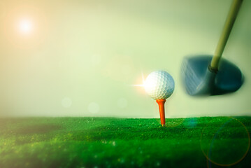 Close-up shot  golf ball on the hitting platform. Golf ball on red hitting platform on beautiful green grass with morning sun.  world play during their holidays for health. Sports and health concepts.
