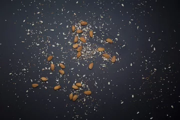 Zelfklevend Fotobehang Cereal grains scattered on the black table preparing light and vegan food © Juan