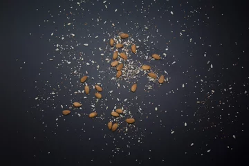 Raamstickers Cereal grains scattered on the black table preparing light and vegan food © Juan