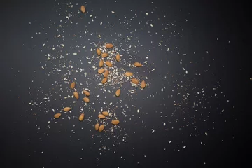 Zelfklevend Fotobehang Cereal grains scattered on the black table preparing light and vegan food © Juan