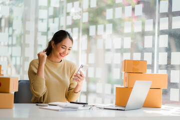 starting a small business SME business owners, successful female entrepreneurs Work with laptops and smartphones with receipt boxes and check online orders to prepare boxes. sell to customers