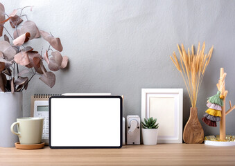 Blank screen tablet on working desk decor with stationery at home