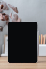 Blank screen tablet on working desk decor with stationery at home