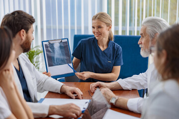 Obraz premium Group of doctors talking sitting at a table in the office of the hospital